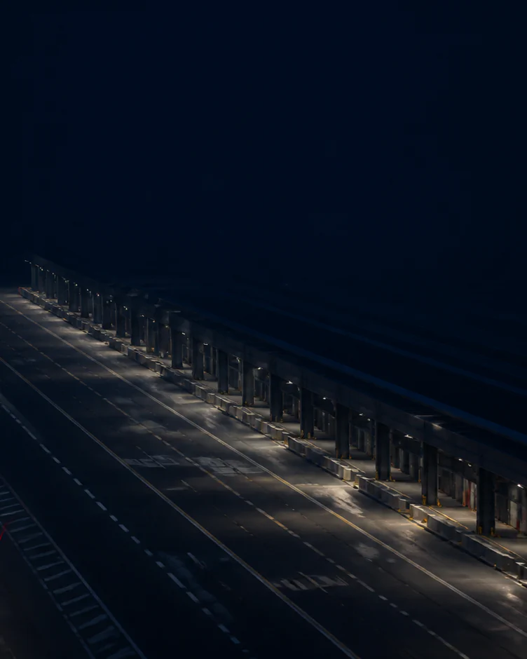 A dark freight terminal roadway with restrained operational lighting